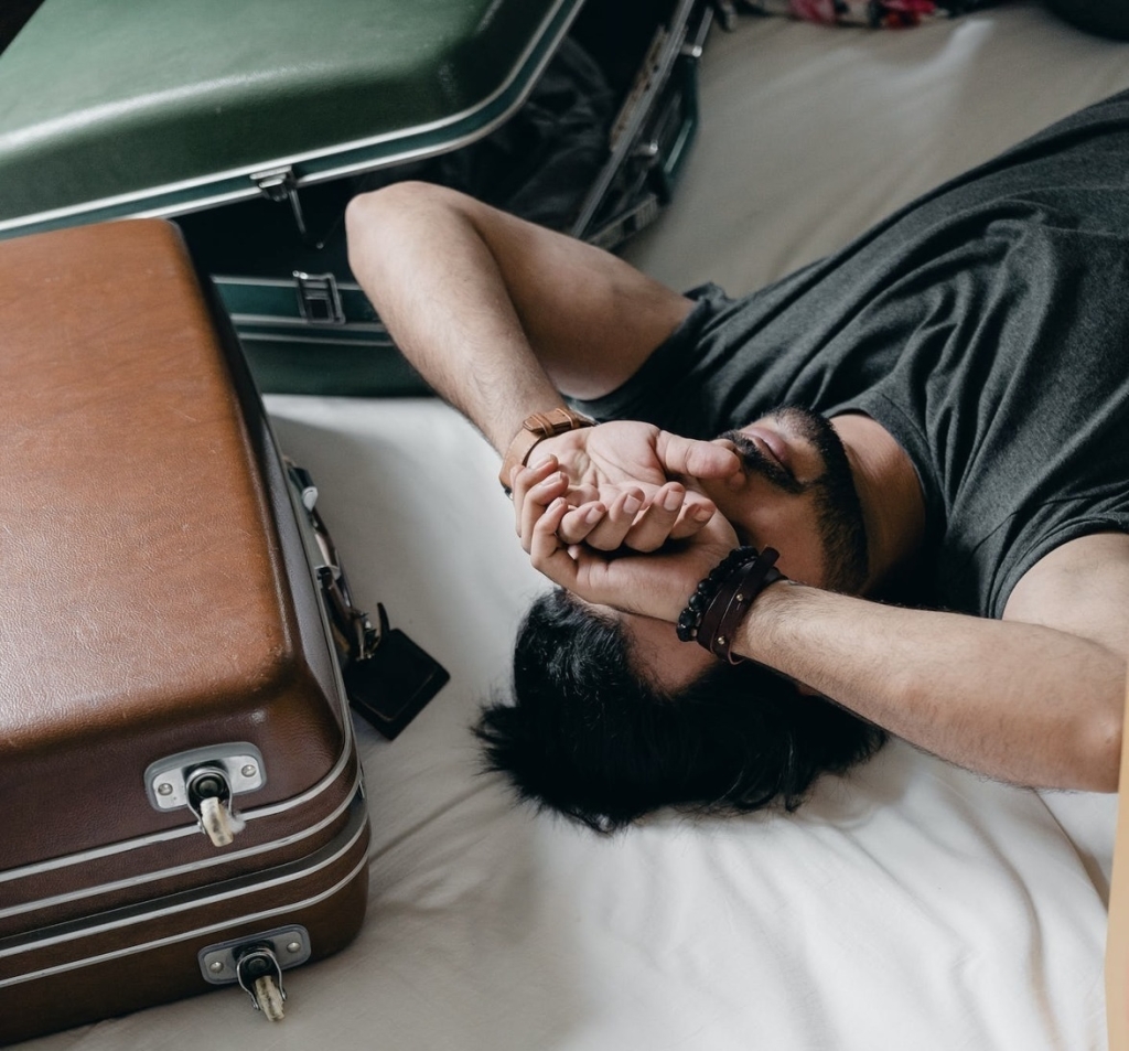 man laying on bed with anxiety