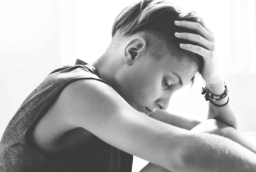 Closeup of young caucasian man sitting who looks depressed