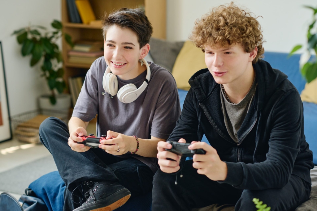 happy teenage girl and boy playing video games