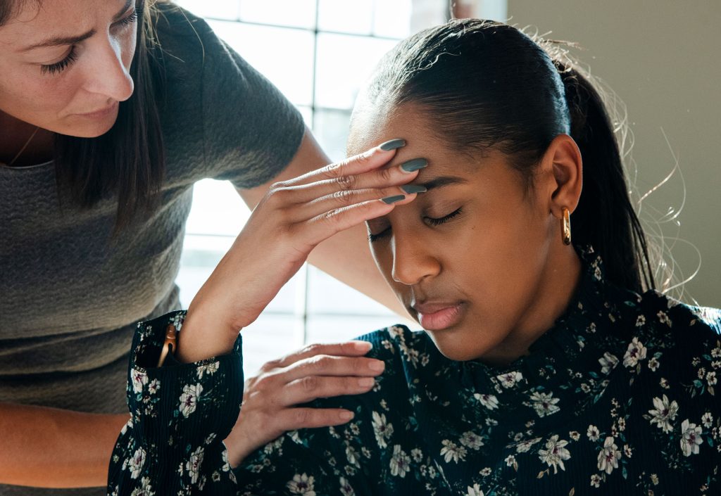 a woman comforting another woman who looks visibly upset