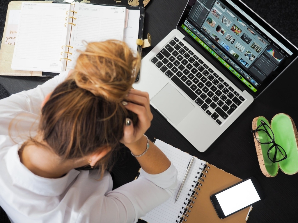 young woman sitting at desk experiencing job burnout